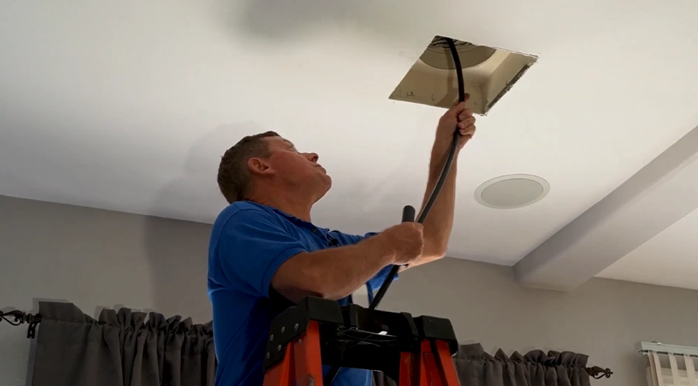 air duct cleaner Air duct cleaning technician inserting camera in a vent to check condition