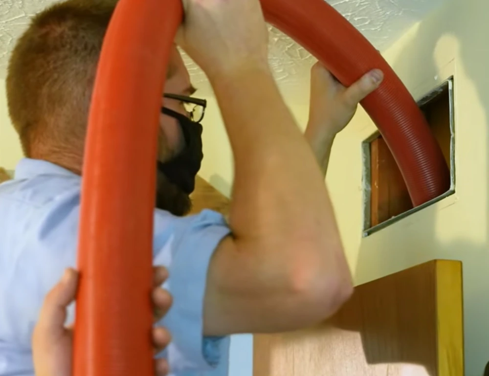 Technician sealing and preparing air duct vents before cleaning in a Tampa home